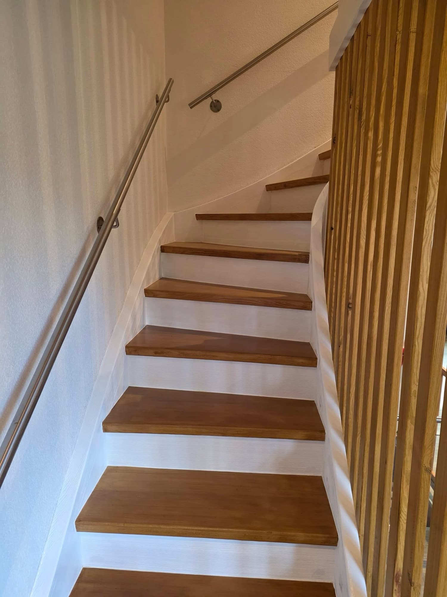 Renovierte Treppe mit frisch gestrichenen weissen Wänden